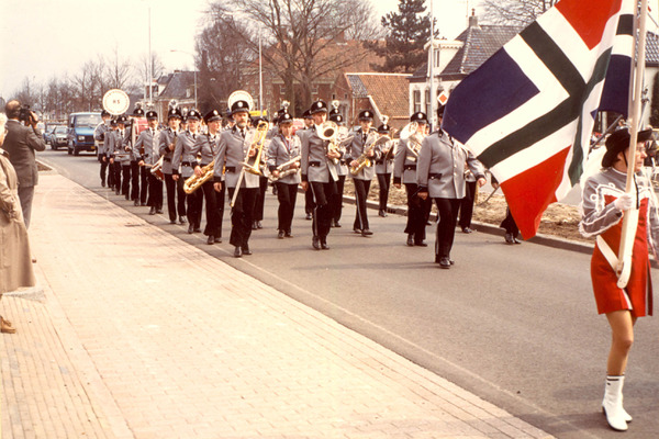 Het fanfarecorps H.S. in 1985, lopende door de straten, vermoedelijk tijdens een evenement.