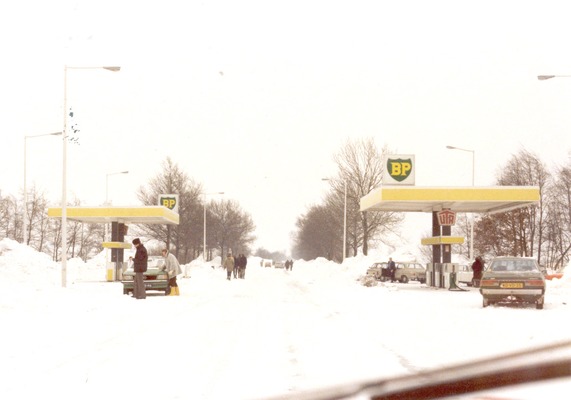 Het BP tankstation in de sneeuw, met een aantal auto's daarbij.