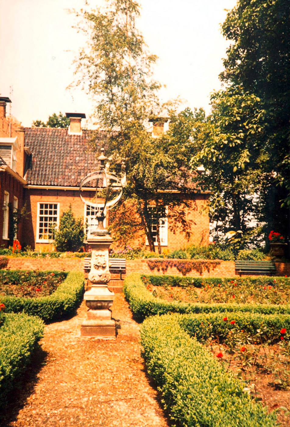 De borg gezien vanuit de tuin met de bekende 'kortgeschoren' symmetrische hagen.