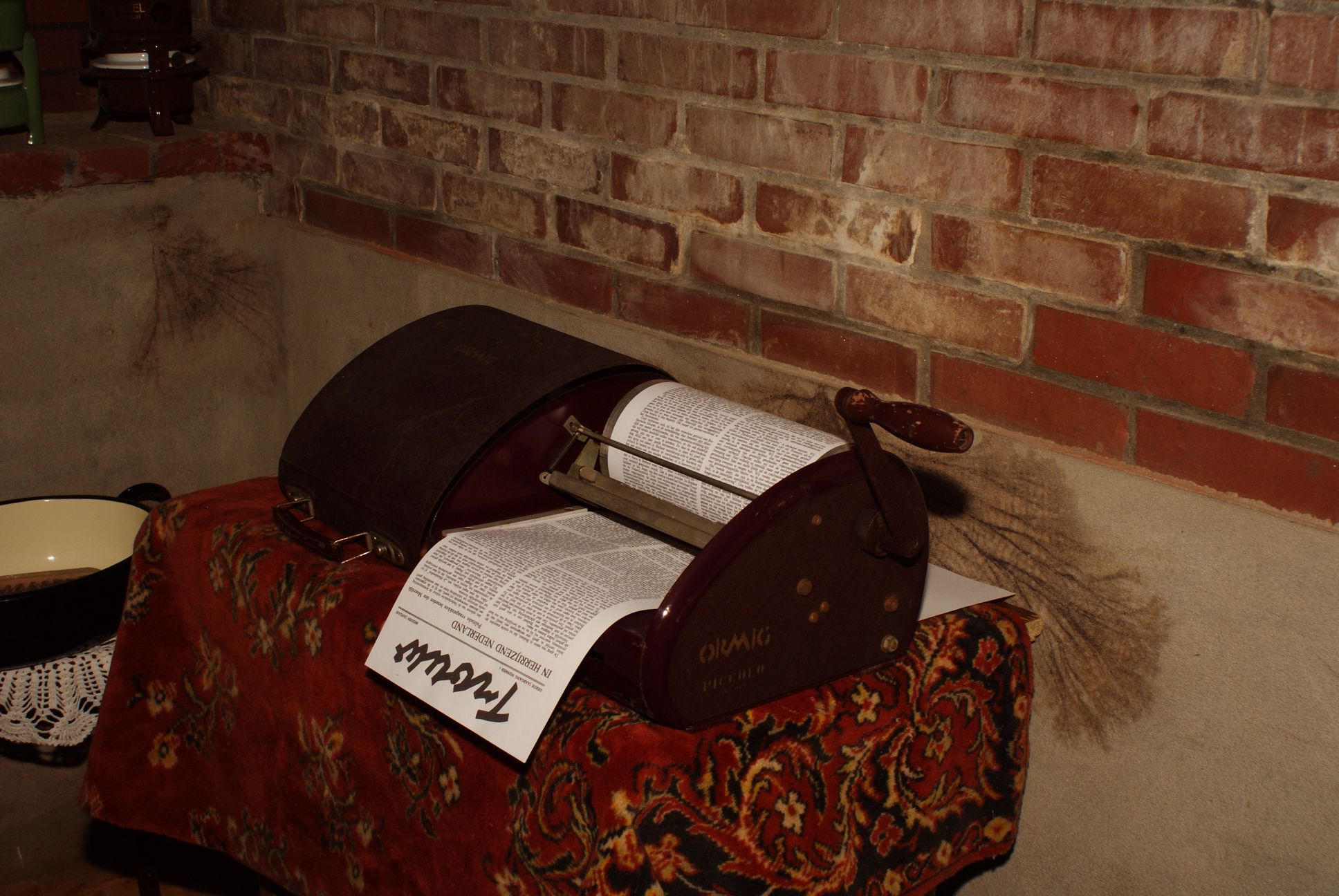 Foto van de kelder met daarin de drukapparatuur met een krant erin.