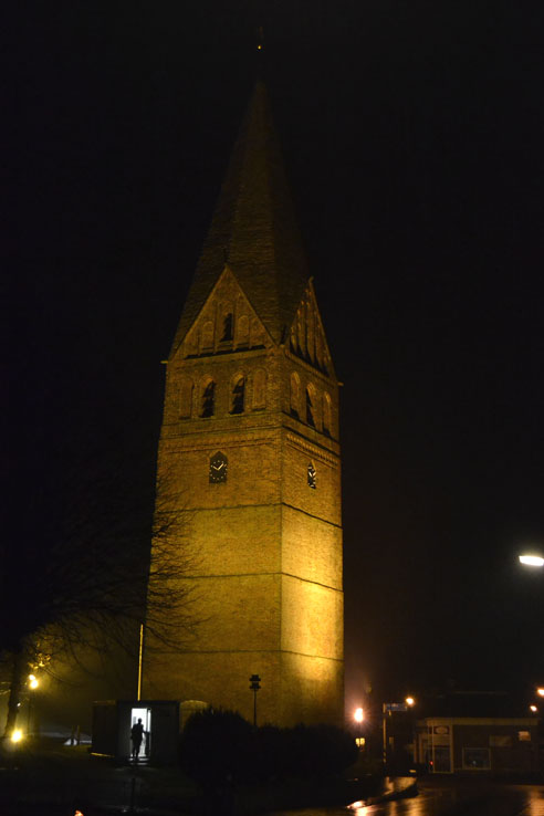 De 17e eeuwse kerktoren van Schildwolde, verlicht van onderen in het donker.