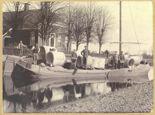 Vervoer van een bijzondere vracht per schip door het Achterdiep. Waar de betonnen elementen voor bestemd waren is niet bekend. De meest rechtse figuur is Hendrik Oldenziel.