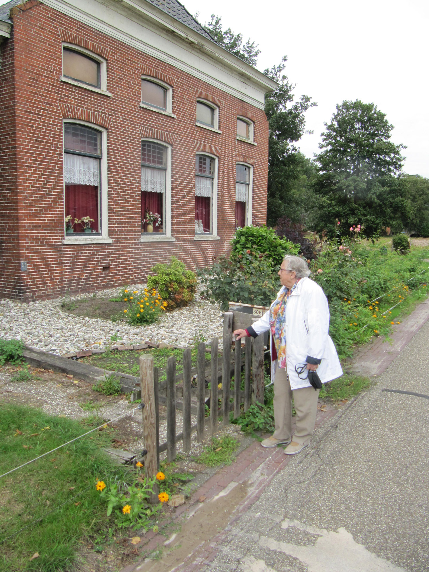 Wil van den Broek-Taal voor de boerderij aan de Dorpsstraat te Kiel-Windeweer, waar zij als hongerkind aan het eind van de oorlog was ondergebracht.