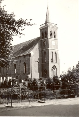 De Nederlands Hervormde Kerk met spitsbogen aan de Woldweg. Op de voorgrond de stenen op het kerkhof.