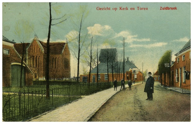 Links de kerk van Zuidbroek met haar toren. Op de voorgrond de straat met een poserende man en 3 kinderen. Rechts nog een aantal huizen.